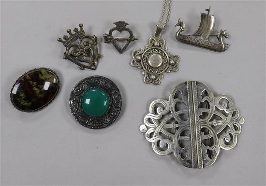 Six assorted silver brooches including Iona and a plated nurses buckle.